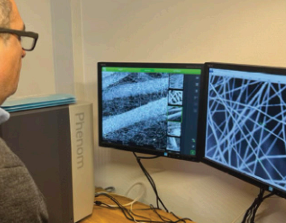 Operator reviewing microscope images on monitors