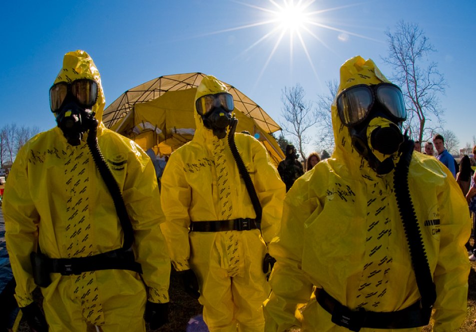 Three people in yellow hazmat suits
